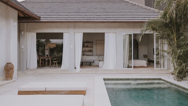 Una casa moderna con piscina, mobili bianchi e zona pranzo.