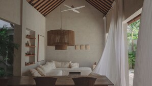 Un'ampia stanza con soffitto alto, un tavolo da pranzo in legno e una ventola a soffitto.