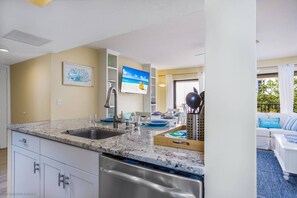 Eine moderne Küche mit Granit-Arbeitsplatten, Edelstahlgeräten und einem Essbereich mit Blick ins Freie.