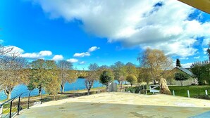 Un parc doté d’une allée pavée, d’arbres et, au fond, d’une étendue d’eau.