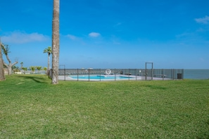 A fenced swimming pool area with a clear view of the ocean. - Allegro North #406 - Dock of the Bay (Rockport)