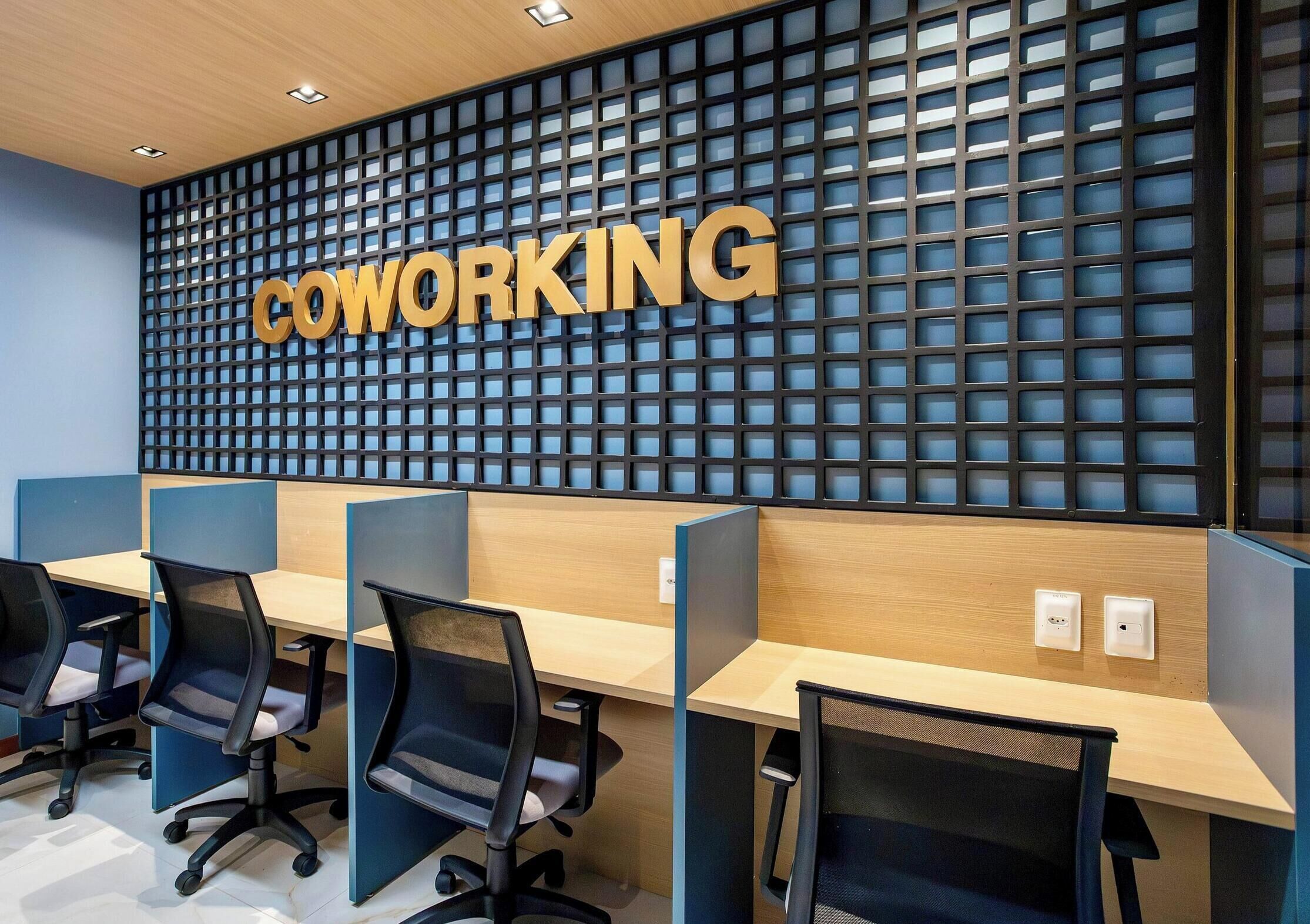 Un espace de coworking doté de cloisons, de bureaux et de chaises.