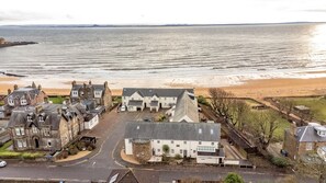Eine Küstenstadt mit historischen Gebäuden, einem Sandstrand und Blick auf das Meer.