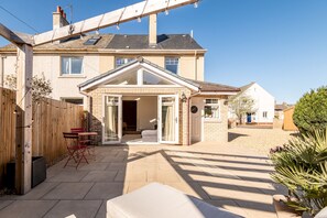 A residential house with a patio, a covered outdoor seating area, and a visible garage. - Auld Burn Road (No 2) (St Andrews)