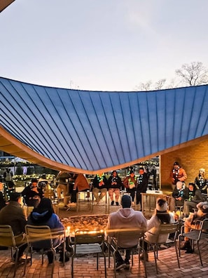 An outdoor seating area with a curved blue roof, stone walls, and brick flooring. - The Downtown Cottage, Stylish & Walkable in Cary (Cary)