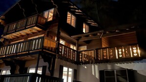 Un edificio de varios pisos con balcones y ventanas, sobre un cielo nocturno estrellado.