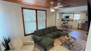 Una sala moderna con un sofá modular, una mesita redonda y una planta en maceta.
