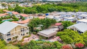 A residential area with multiple houses, a swimming pool, and lush greenery. - Wayaca Resort 2 Bedroom + Pool & Jacuzzi (Jan Thiel)