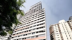 Un immeuble à plusieurs étages, doté d’une architecture moderne, qui présente un mélange de balcons et de fenêtres.