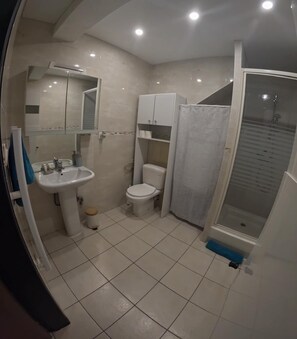 Een douche, handdoeken, toiletpapier