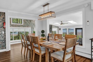 Un comedor con una mesa de madera, sillas y una lámpara colgante.