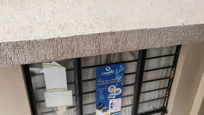 A window with a poster advertising laundry services, a window blind, and a textured wall. - Beautiful Studio apartment in Nairobi near JKIA/SGR perfect for your stay (Nairobi)