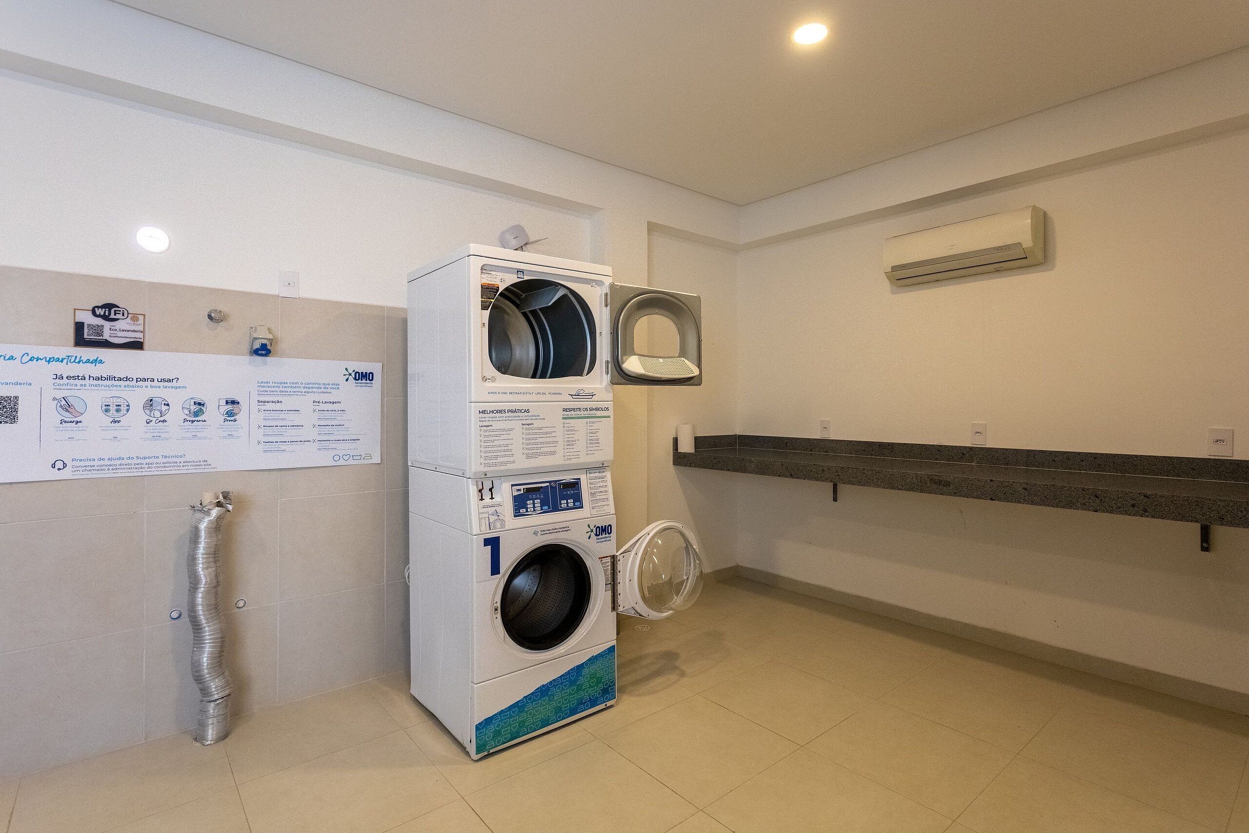 A laundry facility with two washing machines, a drying rack, and a sign with instructions.