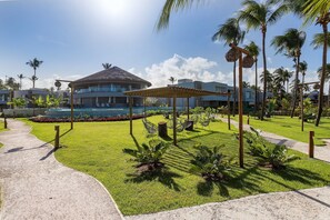 Ein Resort mit Pool, Palmen und einer überdachten Sitzgelegenheit.