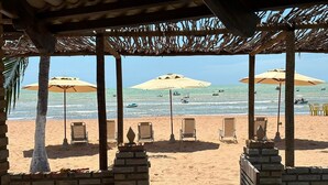 A beachside view with umbrellas, lounge chairs, and a clear view of the sea. - Beachfront House with Pool and Barbecue in Japaratinga (Japaratinga)