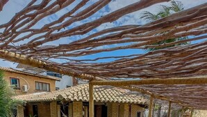A poolside area with lounge chairs, a brick wall, and a pergola structure. - Beachfront House with Pool and Barbecue in Japaratinga (Japaratinga)