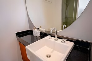 A modern bathroom with a white sink, black countertop, and a large mirror. - DOMINGO DE MORAES  1007 (São Paulo)