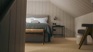 Ein Schlafzimmer mit Bett, Nachttisch, Stuhl und Lampe.