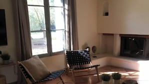 Una sala de estar acogedora con chimenea, un sofá, un sillón y una mesa de centro.