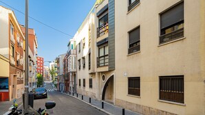 Eine schmale Straße, gesäumt von mehrstöckigen Gebäuden mit Balkonen und unterschiedlichen Architekturstilen.