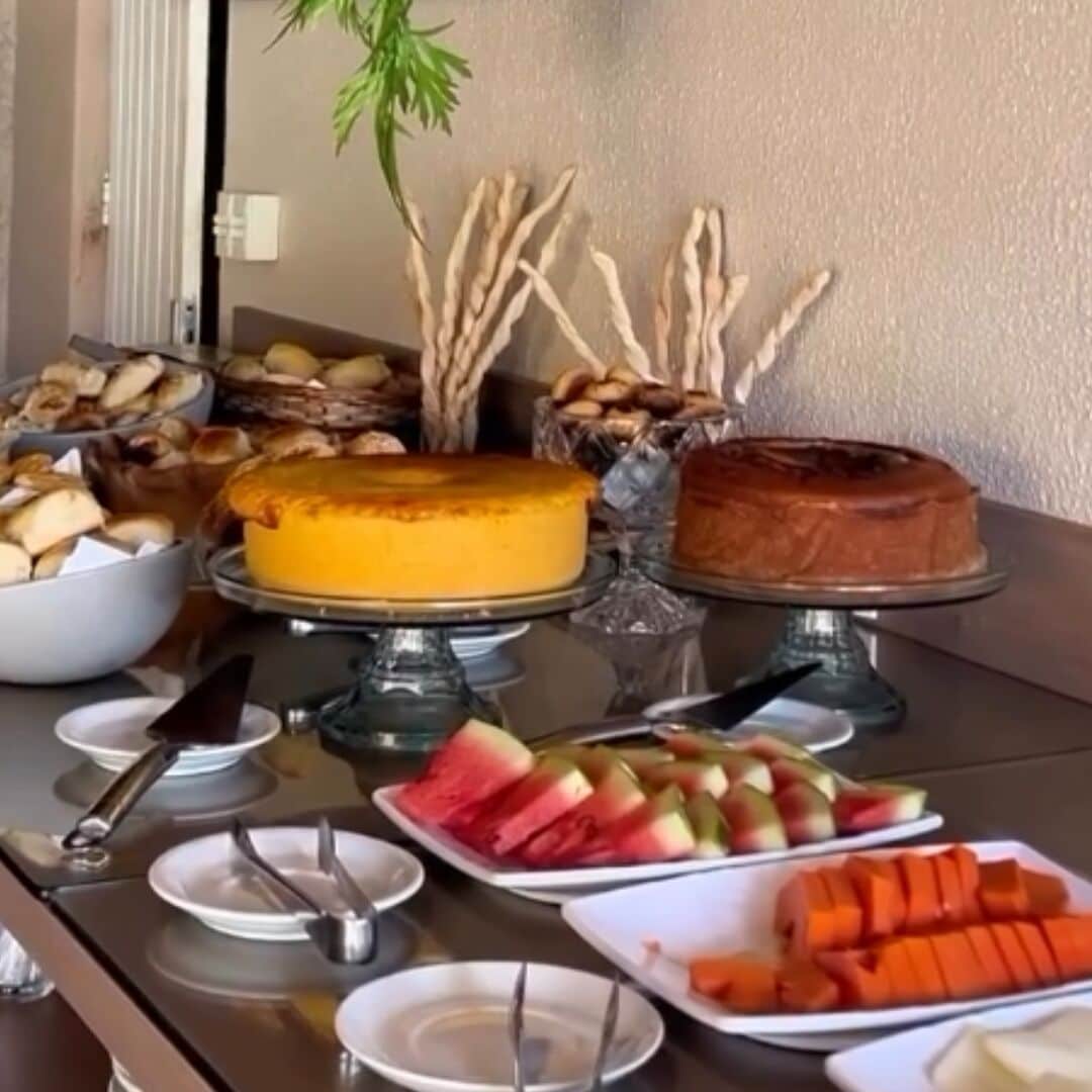 A buffet table with various food items including cakes, fruits, and pastries.