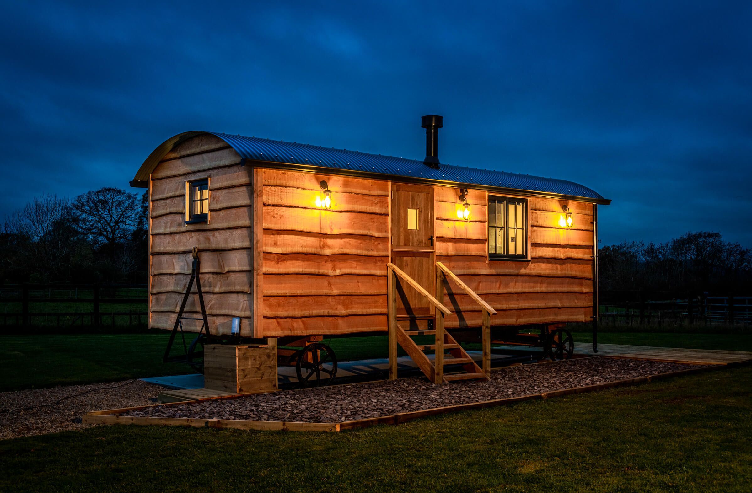 A log cabin with a ramp and a small porch, featuring two windows and a door.
