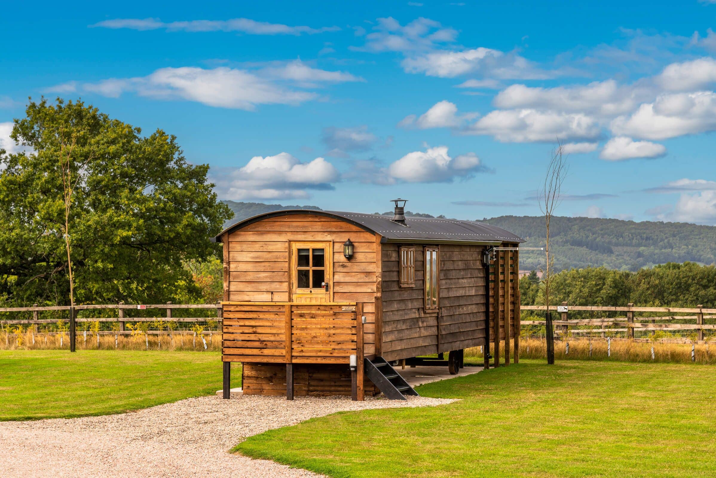 A wooden cabin with a small porch and a ramp leading to the entrance.