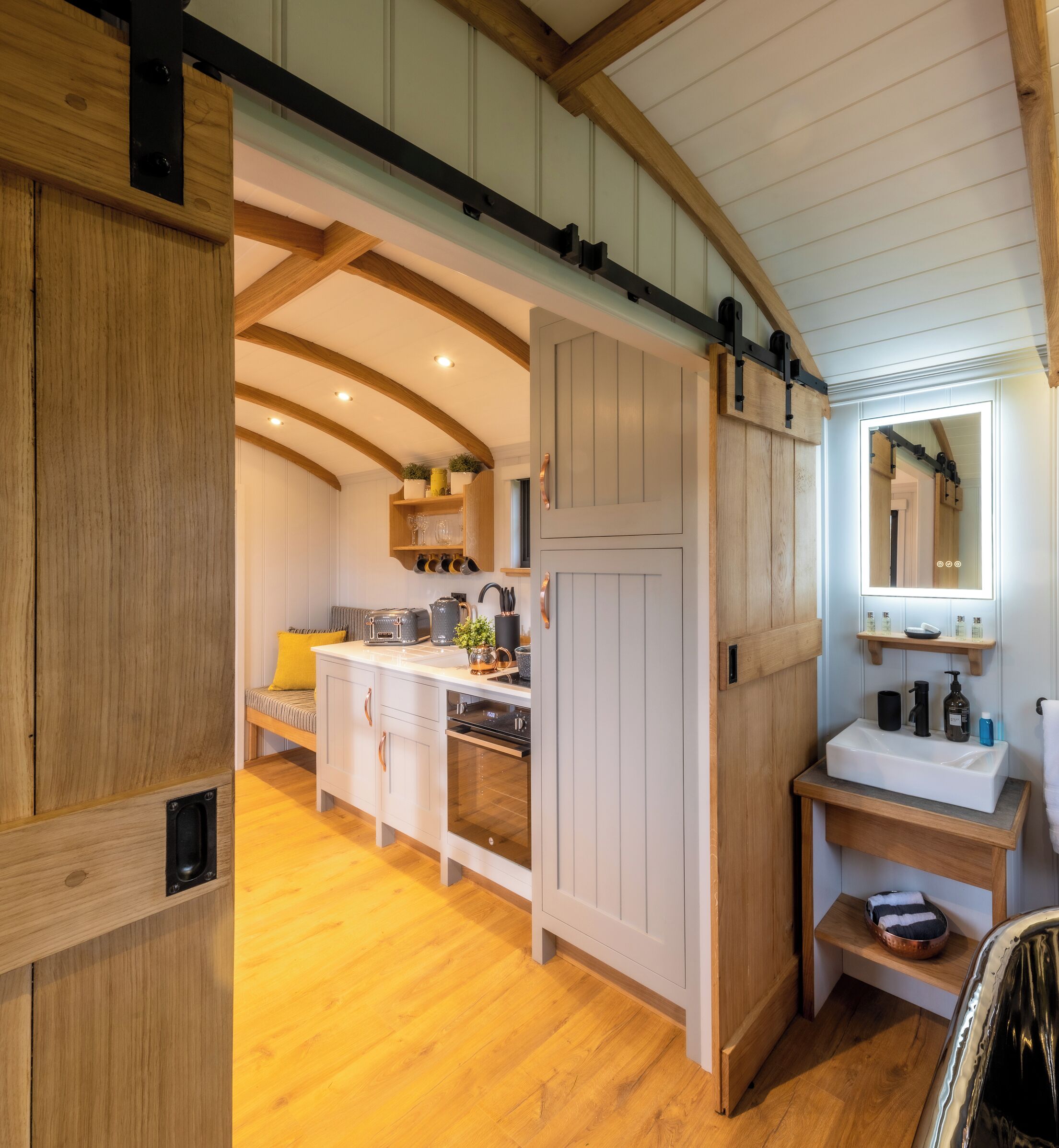 A kitchen with wooden cabinets, a built-in oven, and a breakfast bar.