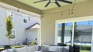 A covered patio with wicker furniture, a ceiling fan, and string lights. - Organic Modern Home, Close to the Beach & Downtown. Community Pool & gym (St. Augustine)