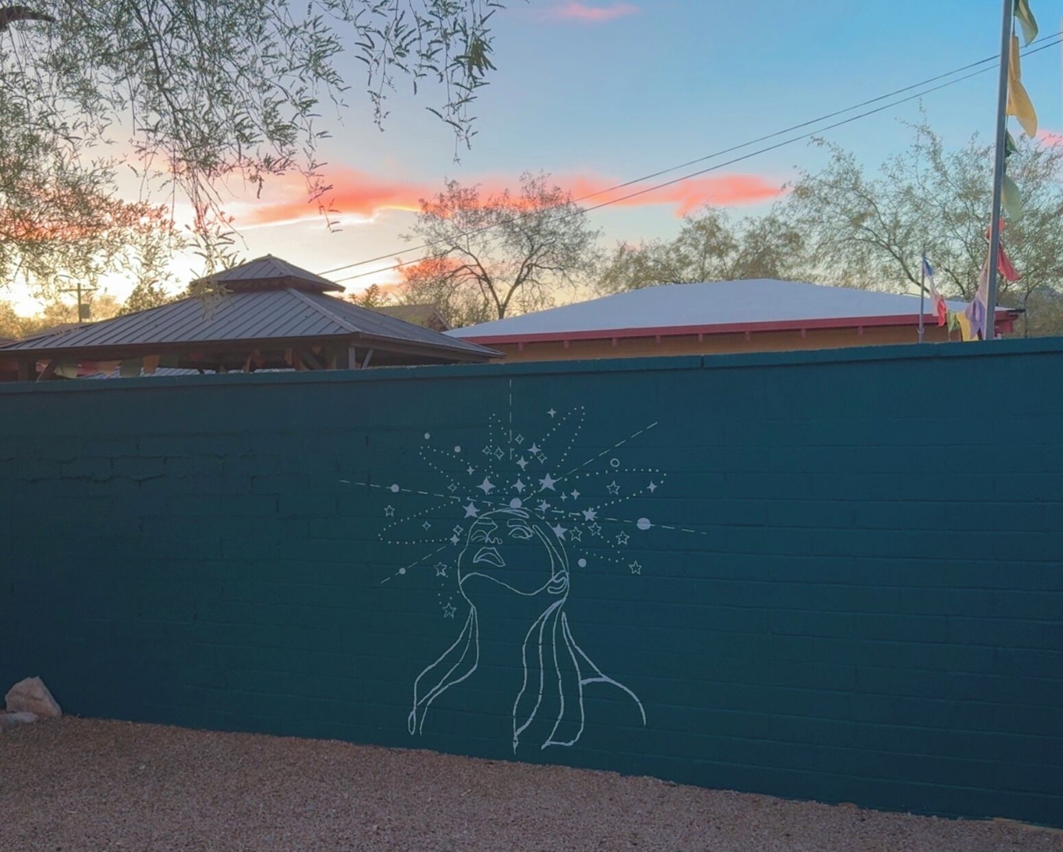 A wall with a mural of a hand holding a starry sky.