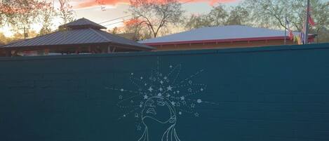 A wall with a mural of a hand holding a starry sky.