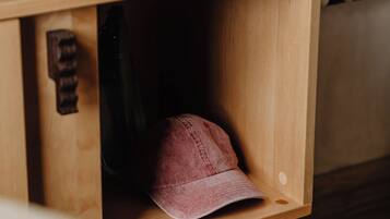 A wooden shoe rack with a pair of shoes and a cap.
