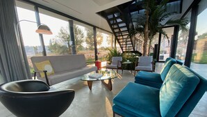 Een moderne woonkamer met een bank, fauteuils en een salontafel.