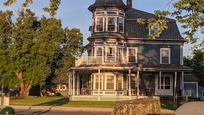 A large, two-story house with a prominent turret and a wrap-around porch. - Peaceful 2-bedroom apartment with AC in charming Canaan (Canaan)