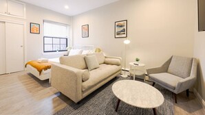 Ein modernes Wohnzimmer mit einer Couch, einem Sessel und einem runden Couchtisch.