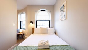A hotel room with a bed, a desk, and a chair. - Spacious Studio | Prudential Area (Boston)