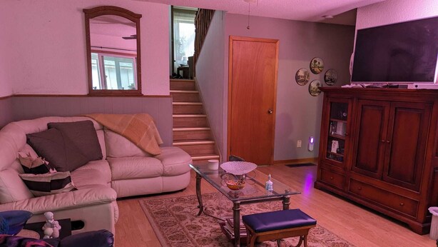 A living room with a sofa, a coffee table, a television, and a cabinet. - Comfortable Private Room in Shared Bungalow | Near Hospital, Schools & Shopping (Peterborough)