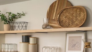 A shelf with various items including a plant, a woven tray, glass jars, and a framed drawing. - Spacious home w/HotTub, Game Room, Backyard Oasis - near Denver/Boulder+Pets OK! (Westminster)