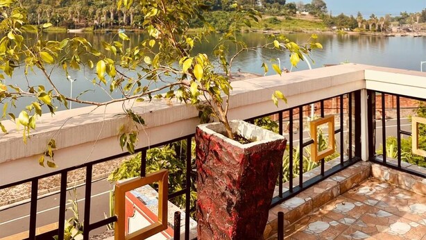 Ein Balkon mit Blick auf einen See und ferne Hügel.