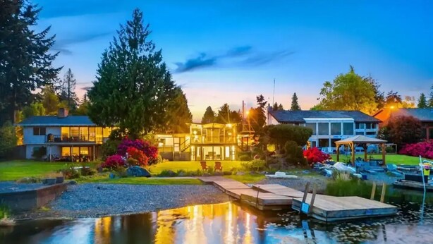 A lakeside property with a dock, a small pond, and a well-maintained garden. - Seattle Lake Front Oasis (SeaTac)