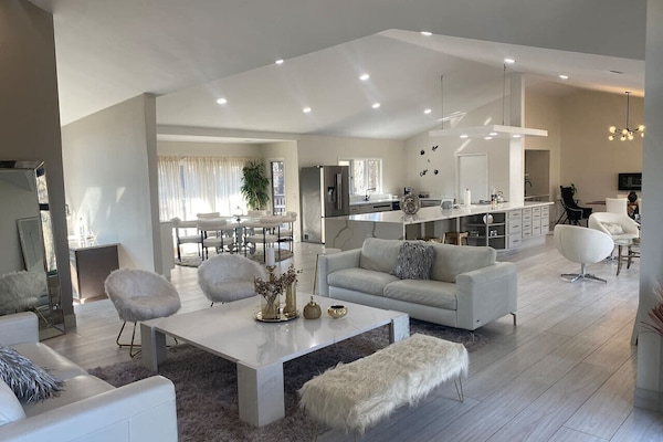 Bright open-concept living room with vaulted ceiling and modern white sofa
