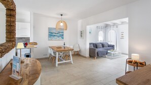 Una sala moderna con un sofá, una mesa de comedor y una zona de cocina al fondo.