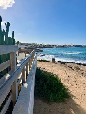 Un muelle de madera con vista a una playa y al océano.