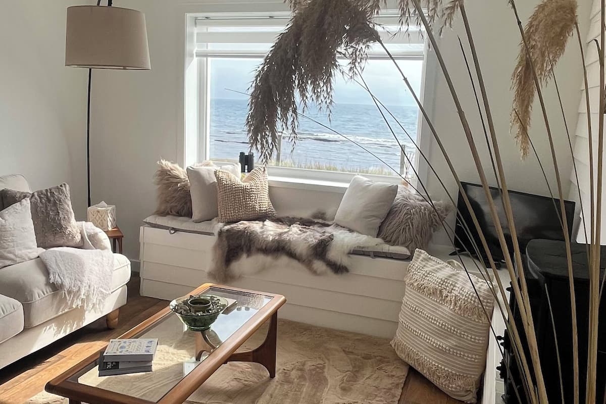 Ein gemütliches Wohnzimmer mit einer Couch, einem Couchtisch und einem Meerblick.