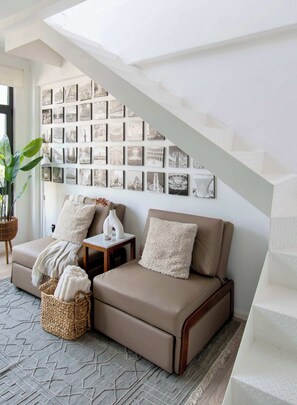 Ein modernes Wohnzimmer mit einem Ecksofa, einem Couchtisch und einer Wand mit Schwarz-Weiß-Fotos.