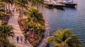 A marina with boats docked, a bridge, and a city skyline in the background. - 5BR West Palm Beach Getaway with Fenced Yard, Pets Welcome (West Palm Beach)