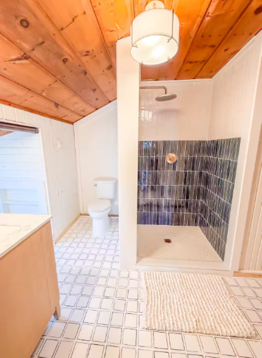 A bathroom with a shower, toilet, and a sink.