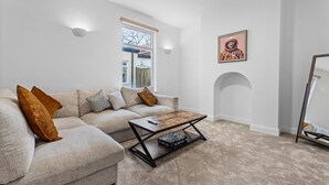Een moderne woonkamer met een modulaire bank, een salontafel en een kunstwerk in een lijst aan de muur.