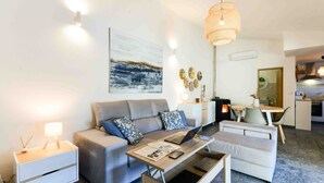 Ein modernes Wohnzimmer mit einer Couch, einem Couchtisch und einem Essbereich mit Tisch und Stühlen.