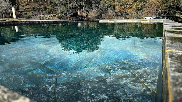 Ein klares Schwimmbecken mit gefliestem Rand und einer Steinbordung.